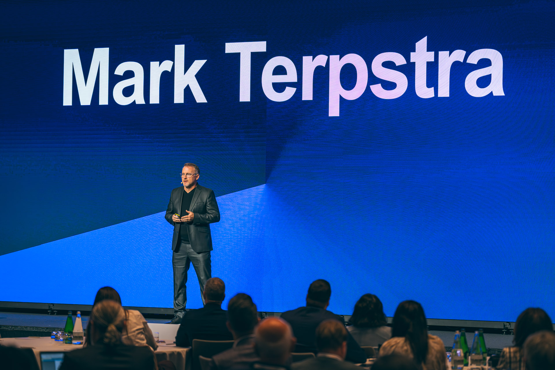Mark Terpstra speaking on stage in front of a screen reading “Mark Terpstra”.